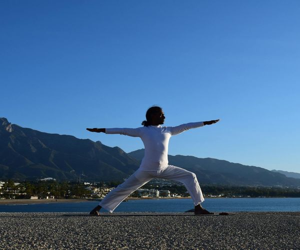 Silhouette of a person in a powerful yoga pose at sunrise.