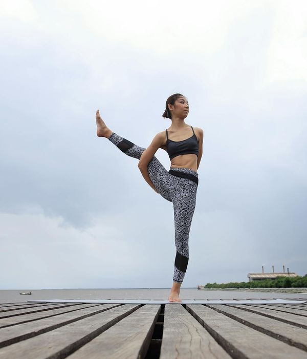 Woman in a calm yoga pose on a travel mat.